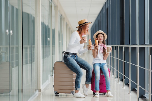 Mutter und ihre kleine Tochter mit Gepäck am Flughafen