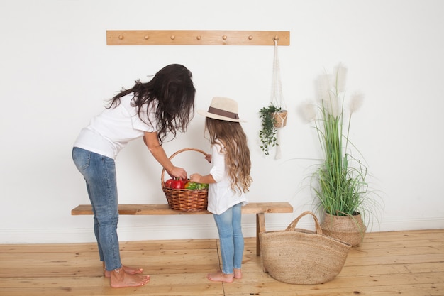 Mutter und ihre kleine Tochter posieren mit Bio-Früchten