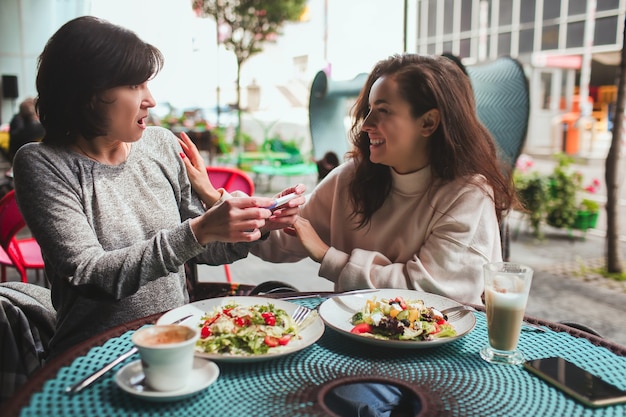 Mutter und ihre kleine Tochter sitzen zusammen im Café