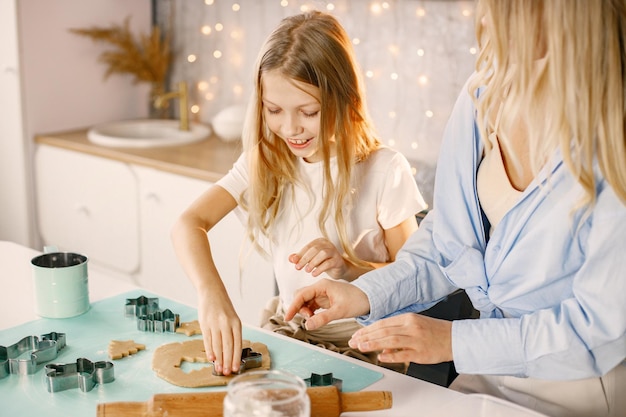 Mutter und ihre Tochter kochen in der Küche Ingwerkekse zu Weihnachten