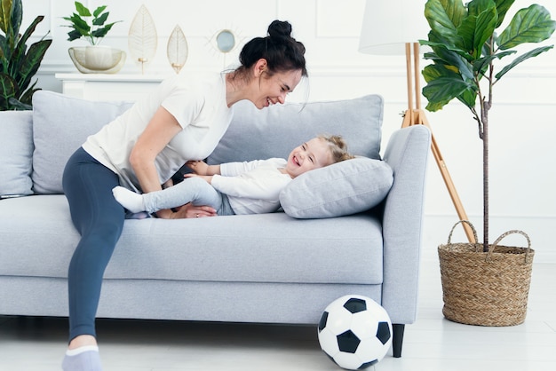 Mutter und ihre Tochter liegen auf der Couch im Wohnzimmer.