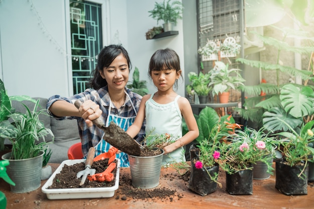 Mutter und ihre Tochter pflanzen Garten