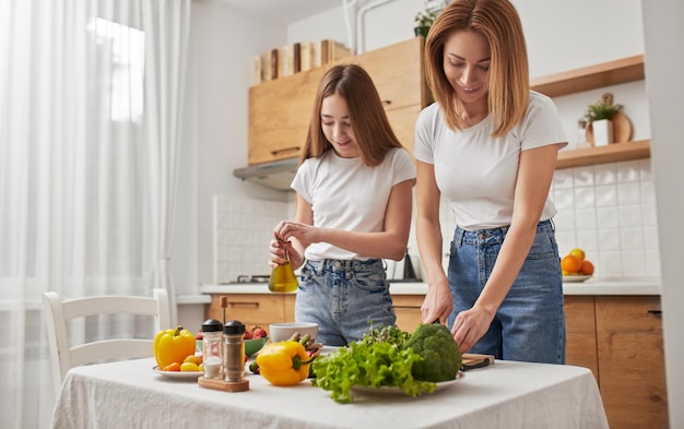 Mutter und jugendlich Mädchen, die zusammen in der Küche kochen