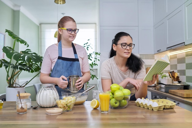 Mutter und jugendliche Tochter kochen zusammen zu Hause
