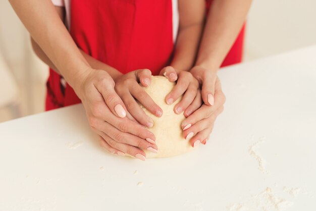 Mutter und junges Mädchen lernen zusammen einen Kuchen backen.