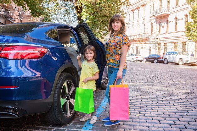 Mutter und Kind auf einer Straße mit Einkaufstüten