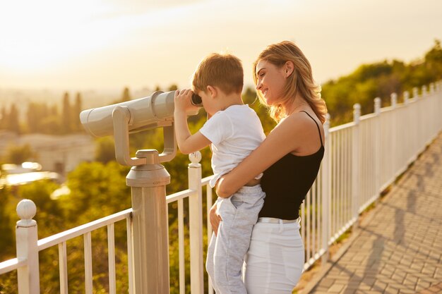 Mutter und Kind beobachten die Natur durch ein Fernglas