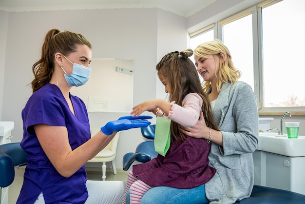 Mutter und Kind besuchen ihren Kinderzahnarzt Arzt im Gespräch mit dem Patienten