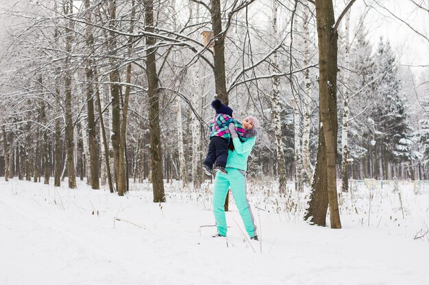 Mutter und Kind, die draußen schönen Wintertag genießen.