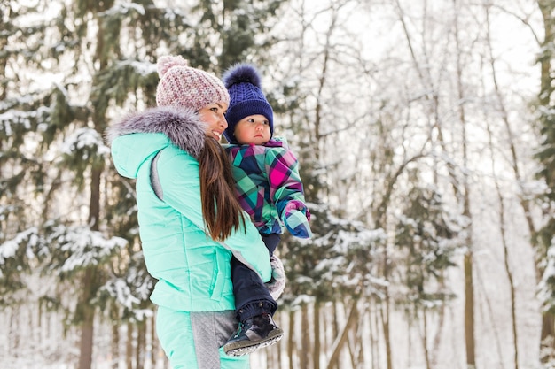 Mutter und Kind, die draußen schönen Wintertag genießen.