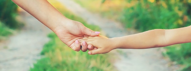 Mutter und Kind gehen an der Hand. Selektiver Fokus.