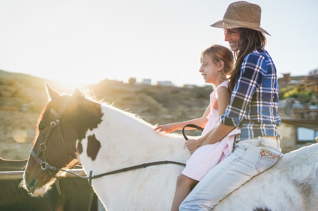 Mutter und Kind reiten Pferd - Familientag - Mutter und kleines Mädchen auf der Ranch - Tierliebe