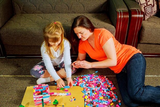 Mutter und Kind spielen zusammen, bauen vom Erbauer.