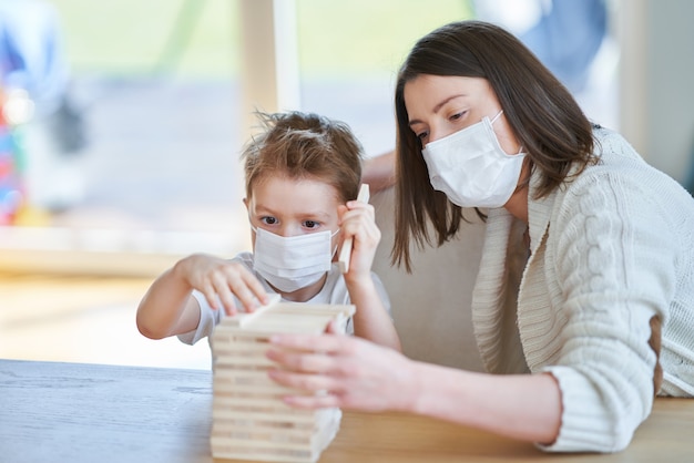 Mutter und Kind spielen zusammen zu Hause Isolation während der Coronavirus-Pandemie