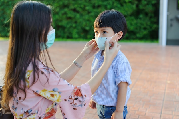 Mutter und Kind tragen während des Ausbruchs des Covid-19-Virus und der Grippe eine Gesichtsmaske.