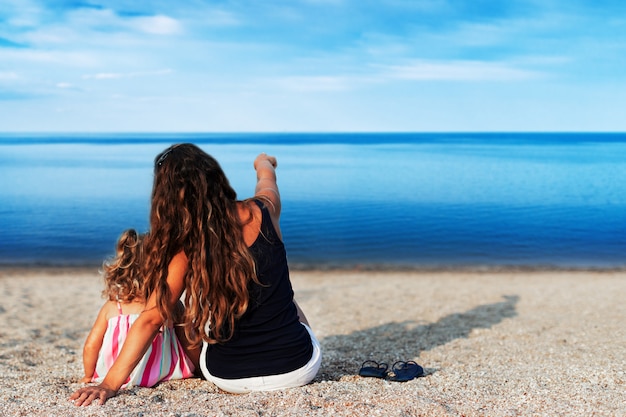 Mutter und Kinder am Strand am Meer