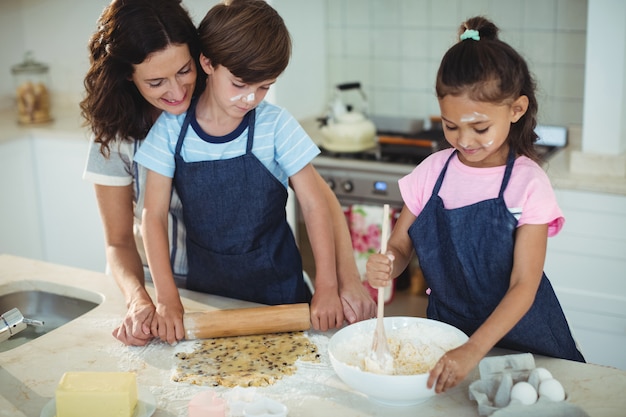 Mutter und Kinder bereiten Kekse in der Küche vor