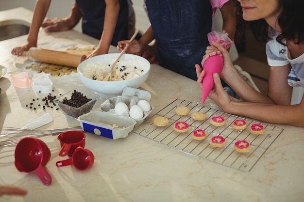 Mutter und Kinder bereiten Kekse in der Küche vor