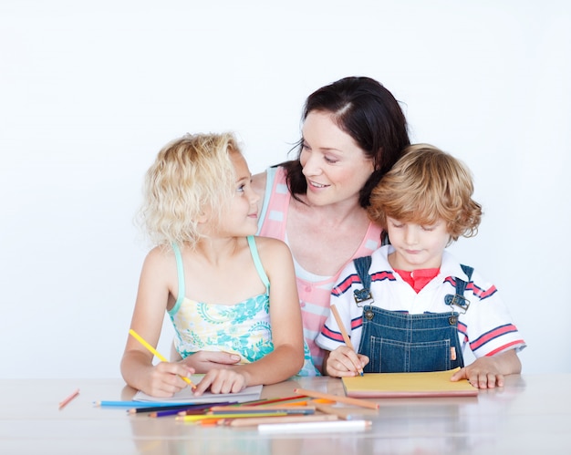 Mutter und Kinder machen Hausaufgaben zusammen