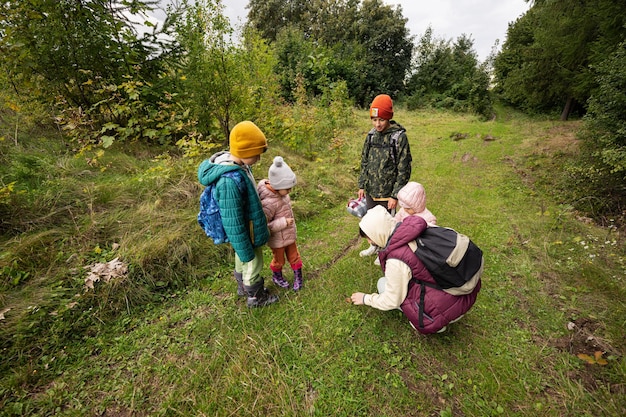 Mutter und Kinder suchen Pilze im wilden Wald