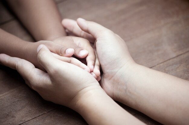 Mutter- und Kindertochter, die Hand zusammen mit Liebe im Weinlesefarbton hält