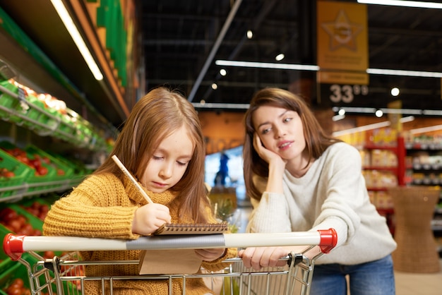 Mutter und kleine Tochter beim Einkaufen im Supermarkt