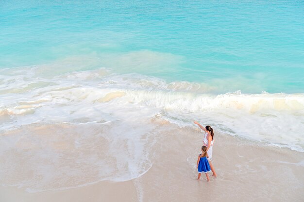 Mutter und kleine Tochter, die Zeit am tropischen Strand genießen