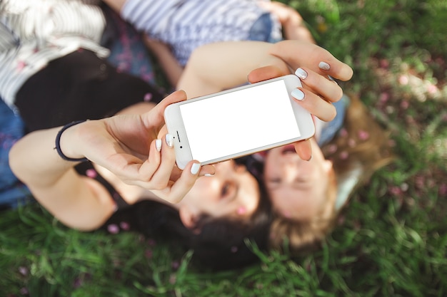 Mutter und kleine Tochter machen Selfie auf Smartphone