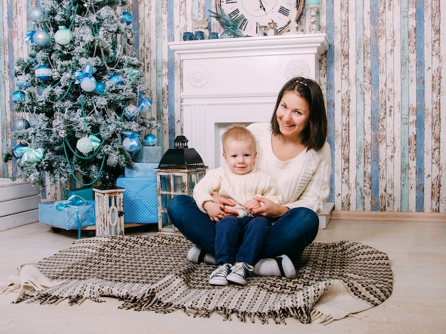 Mutter und kleiner Junge nahe Weihnachtsbaum