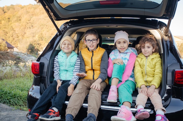 Mutter und kleiner Junge sitzen im Fließheckauto mit Berghintergrund