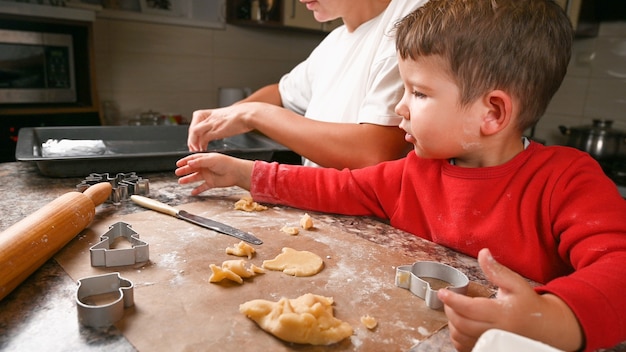 Mutter und kleiner Sohn backen zusammen Kekse