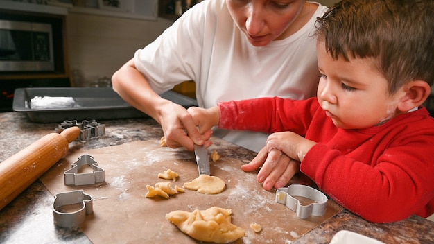 Mutter und kleiner Sohn backen zusammen Kekse