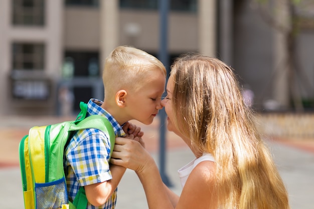 Mutter und kleiner Sohn berühren Nasen vor der Schule