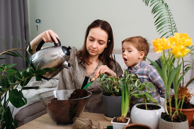 Mutter und kleiner Sohn verpflanzen gemeinsam Zimmerpflanzen