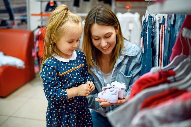 Mutter und kleines baby kaufen kleidung im kinderladen