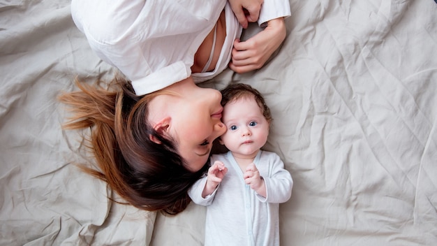 Mutter und kleines Kind liegen auf dem Bett