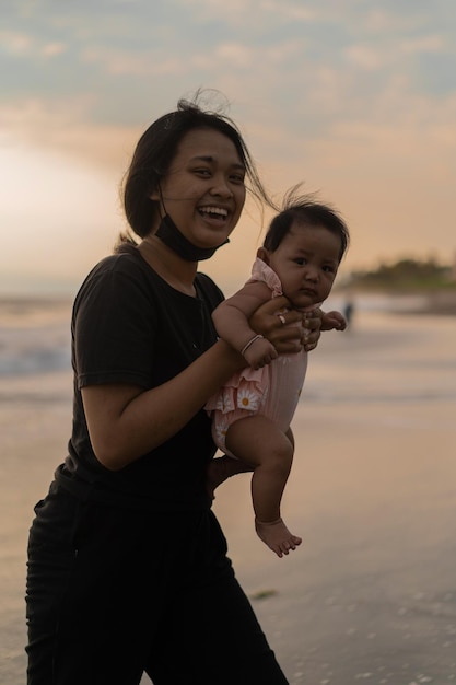 Mutter und neugeborene Tochter am Strand