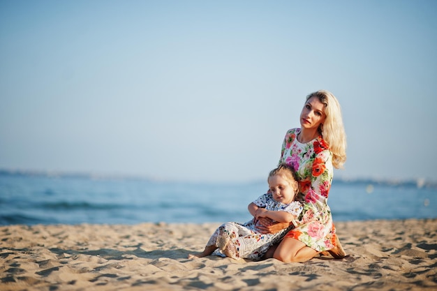 Mutter und schöne Tochter, die Spaß am Strand haben Porträt einer glücklichen Frau mit einem süßen kleinen Mädchen im Urlaub