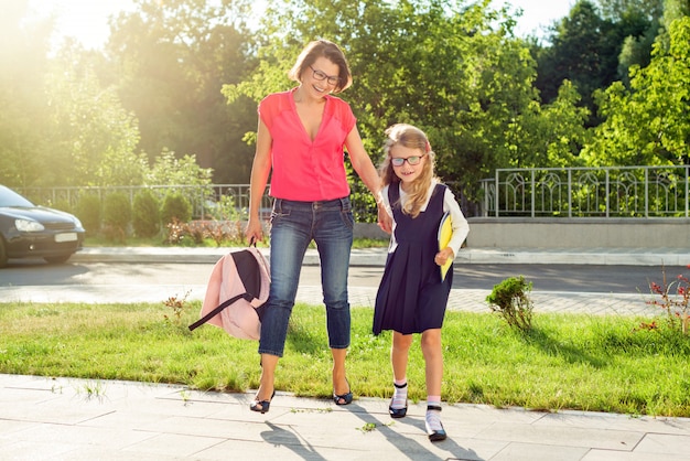 Mutter und Schüler des Grundschulhändchenhaltens.