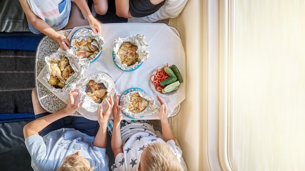 Foto mutter und söhne essen am klapptisch zu mittag und reisen mit dem zug aus der nähe der oberen ansicht