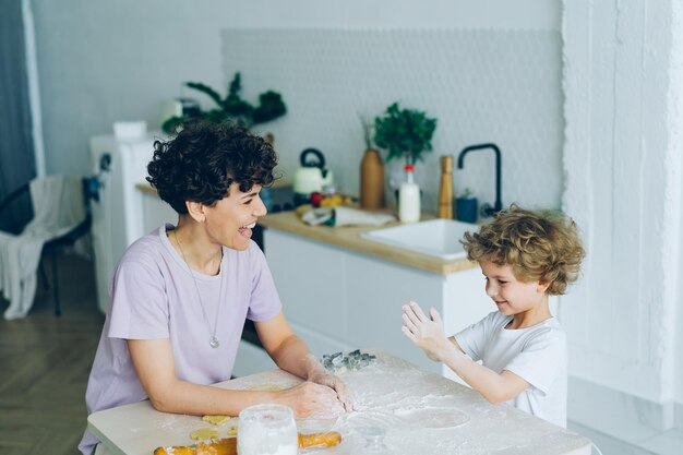 Mutter und Sohn amüsieren sich mit Mehl beim Kochen hausgemachter Kekse in der Küche