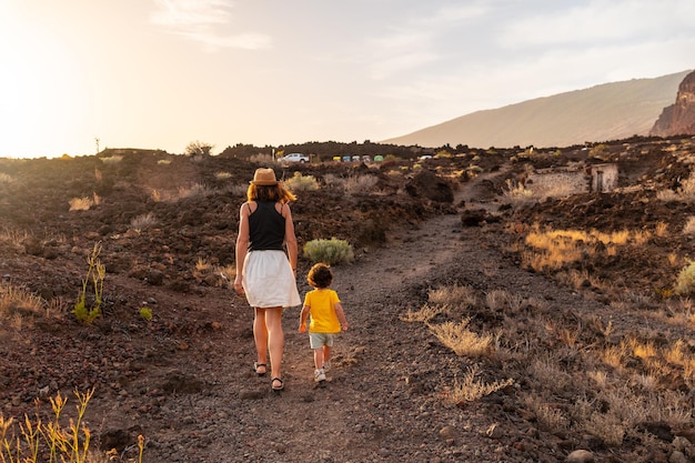 Mutter und Sohn auf einem Wanderweg bei Sonnenuntergang am Strand von Tacoron auf den Kanarischen Inseln El Hierro