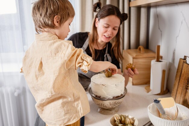 Foto mutter und sohn backen karottenkuchen zusammen in der gemütlichen küche, kochen zu hause, familienleben