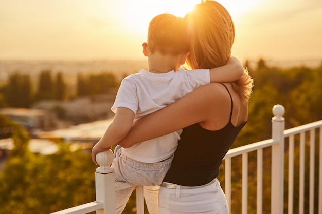 Mutter und Sohn bewundern den Sonnenuntergang im Sommer