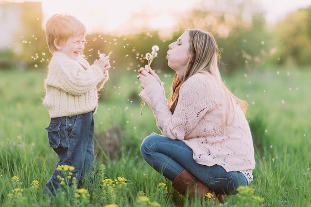 Mutter und Sohn bläst Löwenzahn