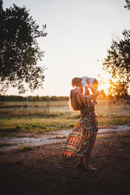 Mutter und Sohn, die im Sonnenuntergang umarmen