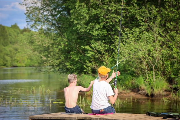 Mutter und Sohn fangen Fische im Fluss