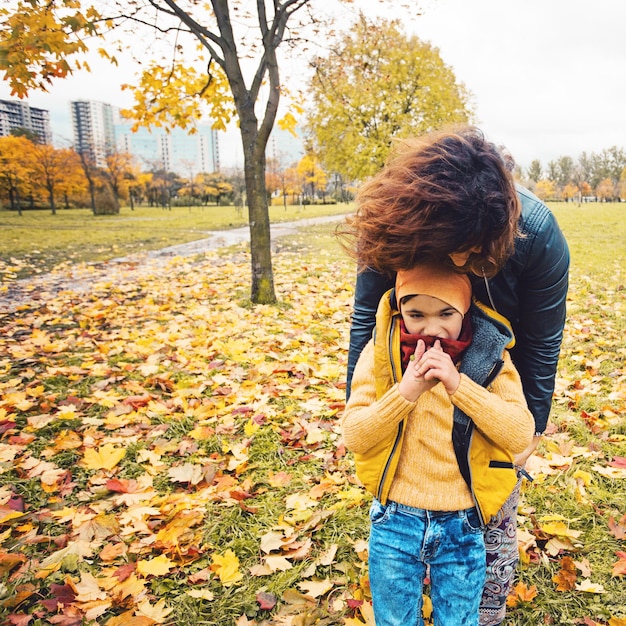 Mutter und Sohn gehen im Herbstpark Liebespflege und positive Beziehungen Mutter und Sohn zusammen glückliche Familie