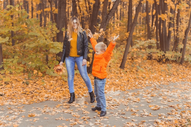 Mutter und Sohn gehen im Herbstpark spazieren und genießen die schöne Herbstnatursaison einzeln