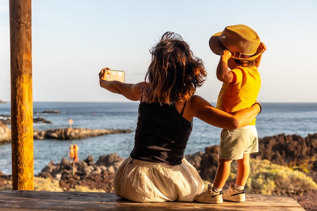 Mutter und Sohn im Urlaub fotografieren am Strand von Tacoron auf den Kanarischen Inseln El Hierro Spaß haben Junge in einem Hut